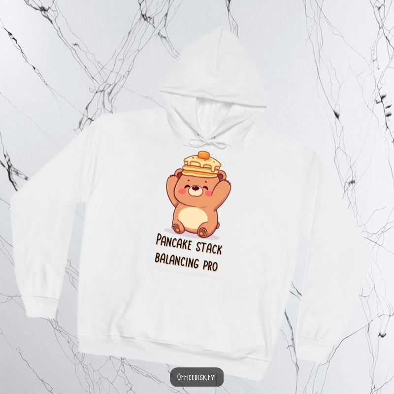 Funny hoodie depicting a lovable, clumsy bear attempting a precarious pancake stack balance on its head, radiating playful chaos and warmth.